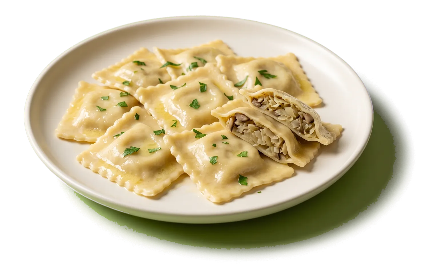 A plate of square ravioli in melted butter with chopped parsley, one ravioli cut in half to show the filling